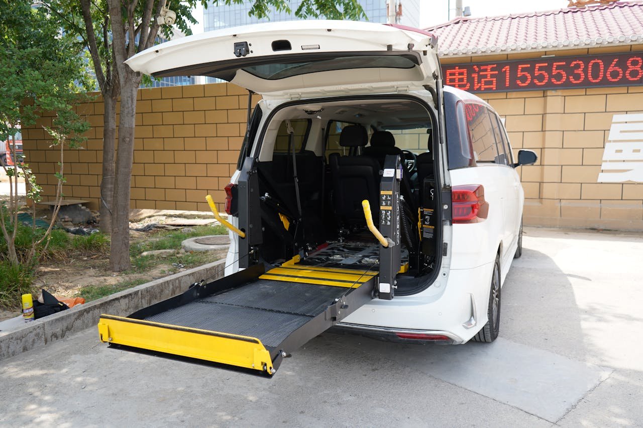 A minivan equipped with a wheelchair lift parked outdoors. Ideal for accessibility themes.